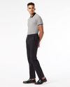 Side view of model wearing Black Men's Slim Fit Smart 360 Flex Ultimate Chino Pants.