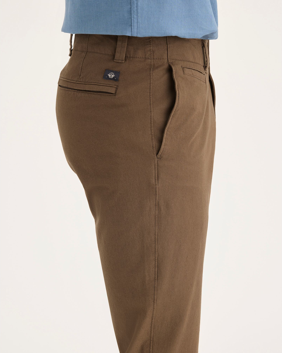 Side view of model wearing Coffee Liquer Men's Skinny Fit Smart 360 Flex California Chino Pants.