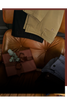 Clothing items including a beige jacket, black pants, and a brown leather chair.