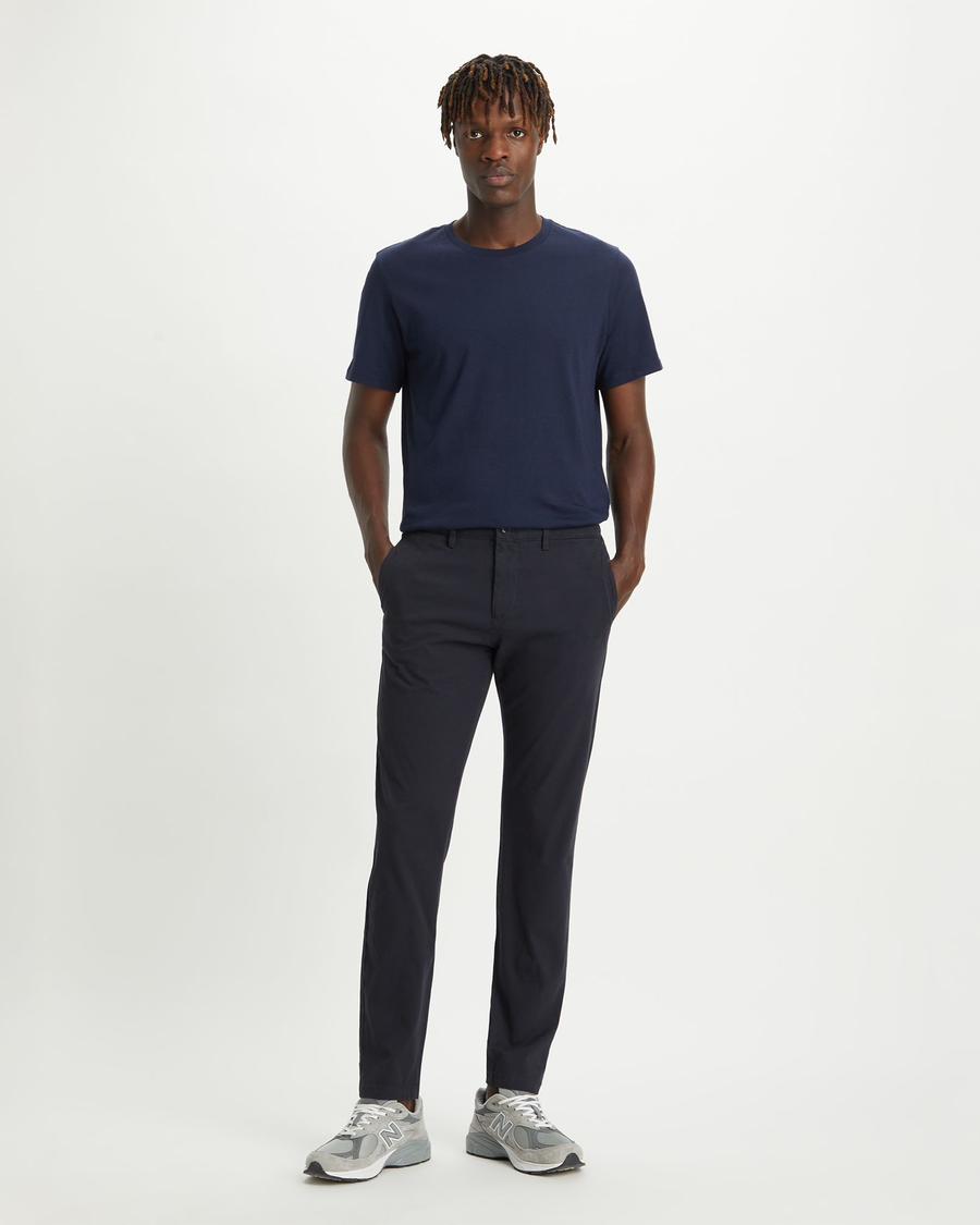 Front view of model wearing Dockers Navy Men's Slim Tapered Fit Smart 360 Flex Alpha Chino Pants.