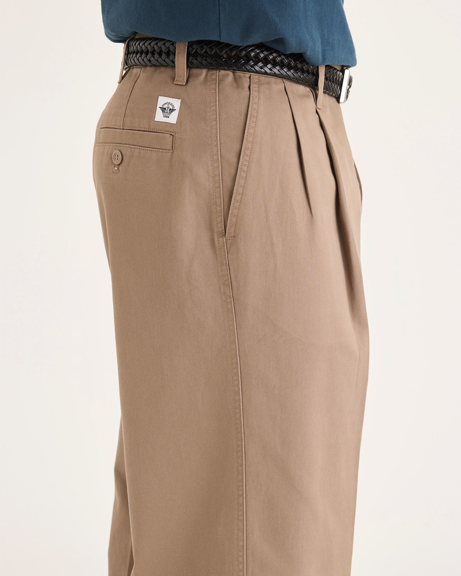 Side view of model wearing Fossil Men's Loose Fit Eighty-Six Original Pleated Chino Pants.