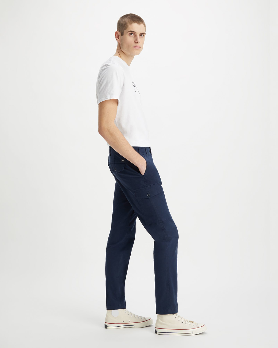 Side view of model wearing Navy Blazer Men's Slim Tapered Fit Cargo Pants.